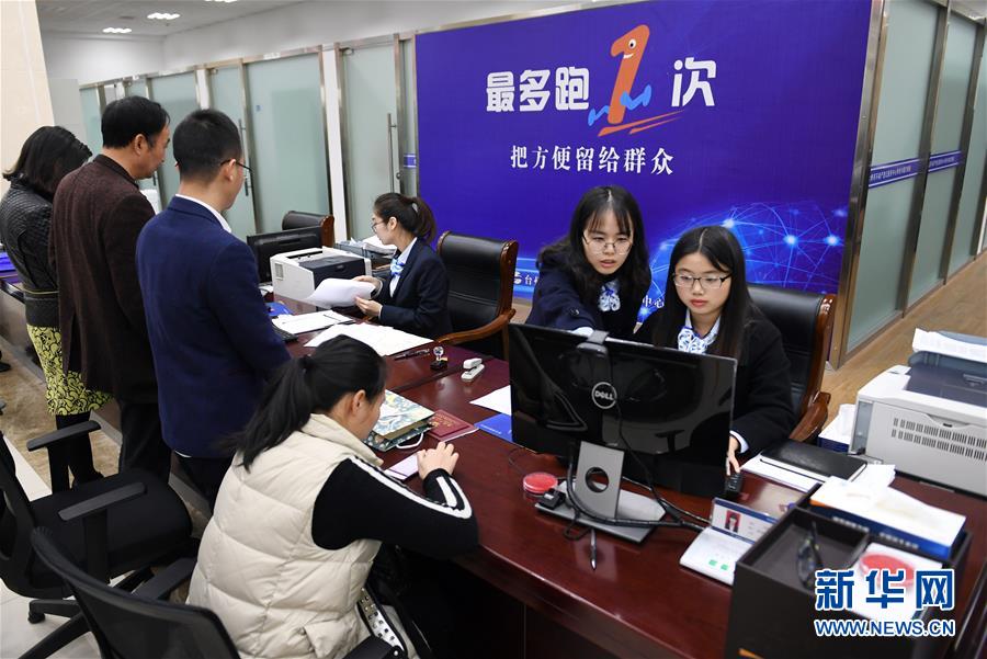  2018年3月28日，浙江省台州市行政服务中心的工作人员在给市民办理业务。顺应人民群众呼声，浙江提出“最多跑一次”改革，体现以人民为中心的发展思想。新华社记者 殷博古 摄